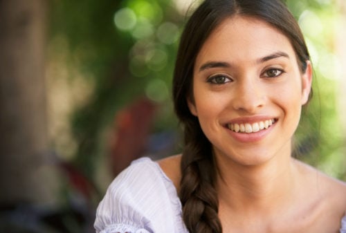 close up of a brunette young woman with a big smile showing that she is a happy Christian