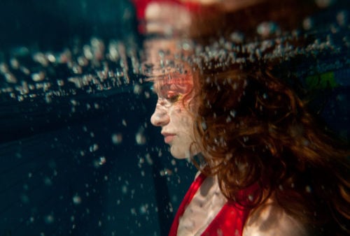 Woman in red under water, as we study about the experience of salvation in Christ, revealed in Scripture