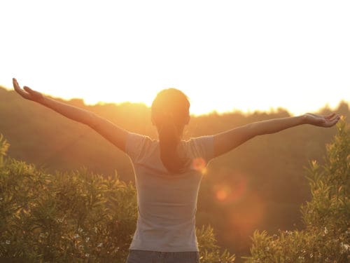 Woman with arms outstretched towards eternal life