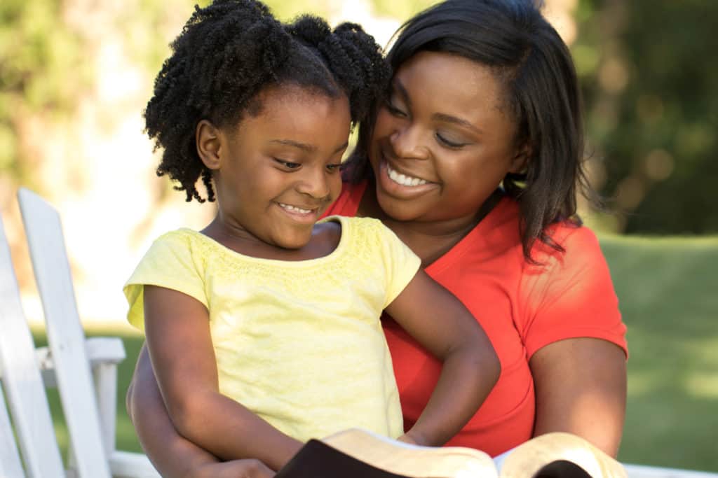 mother and daughter reading the bible to help with their daily life