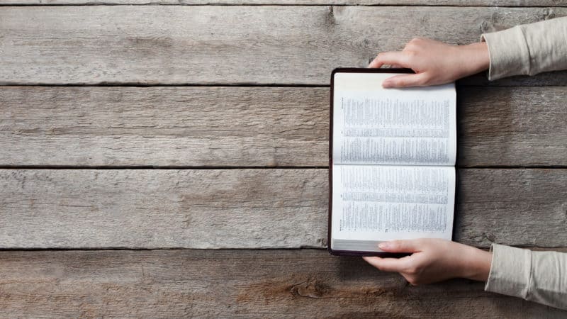 Woman studying open Bible to gain understanding from it