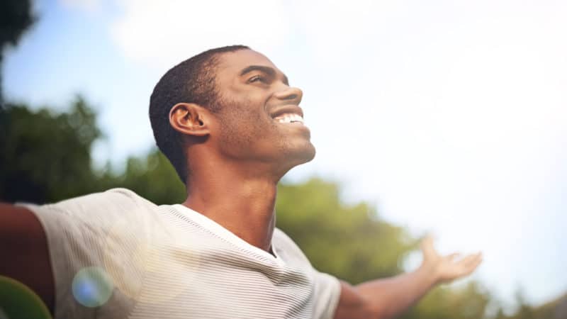 Man with arms outstretched because he is happy to understand the Bible better