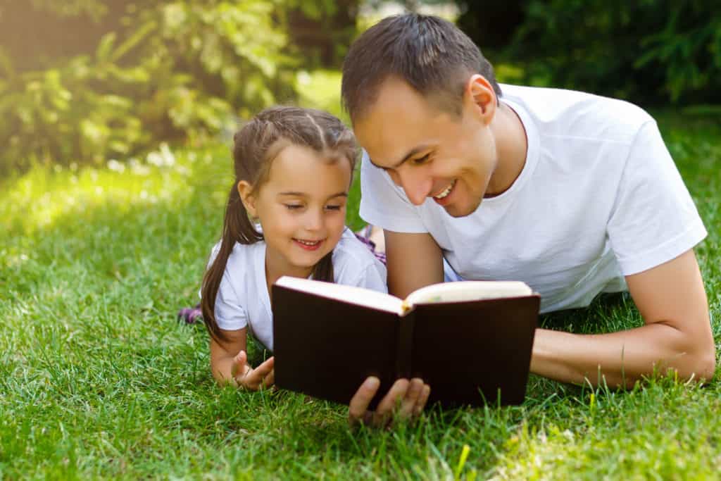 father teaching his daughter how to have a beginner's bible study