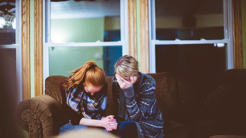 Two women praying to better understand what a prophet is