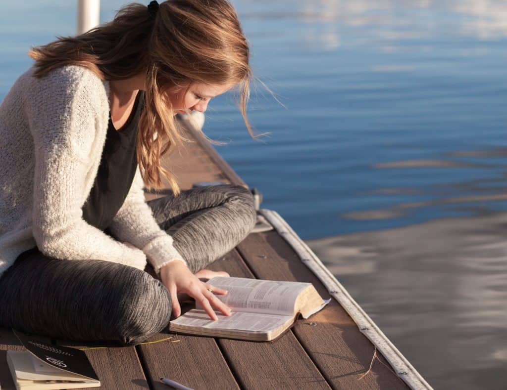 woman sitting on dock learning about how to study the bible