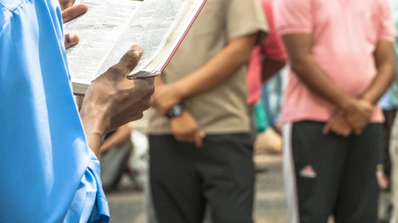 Mann holder en bibel undervisning et publikum om profeter