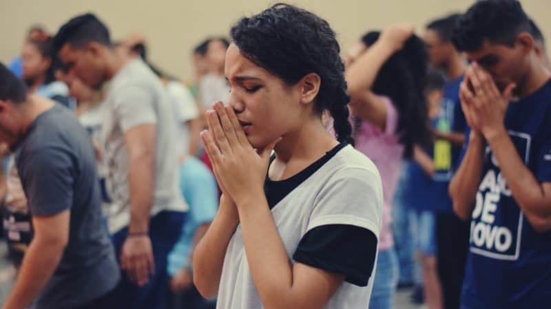 group of youth earnestly in prayer before having a Bible study