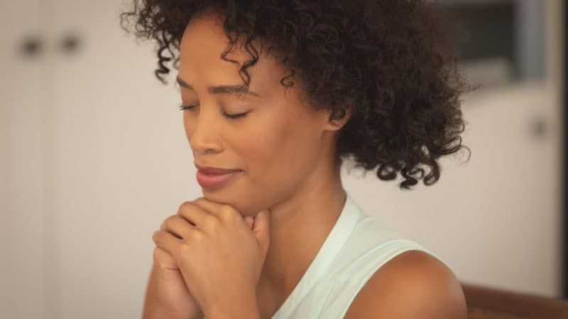 Woman praying to understand what it means to be a prophet