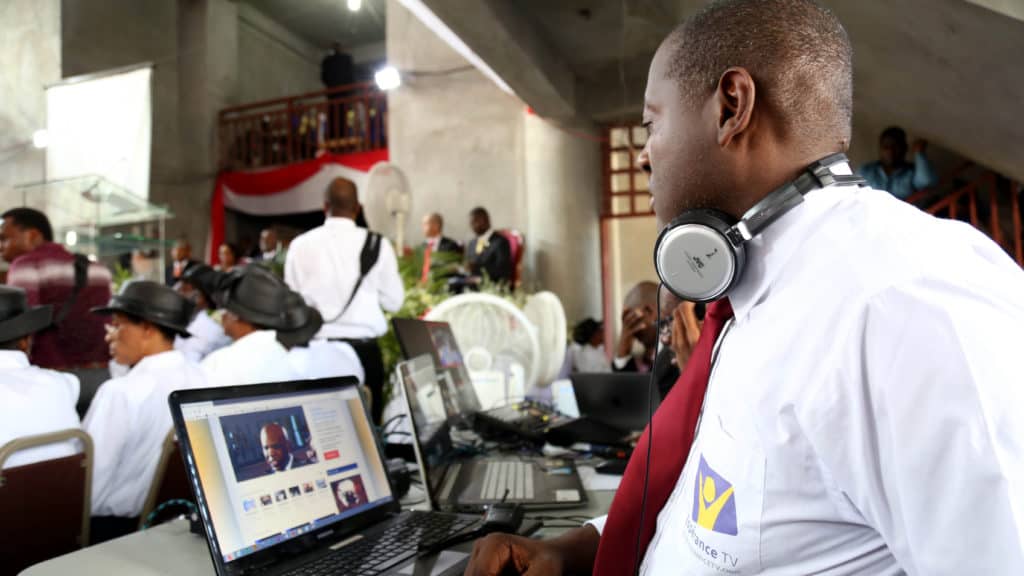 Man with headphones around neck recording sermon for Hope Channel's TV ministry