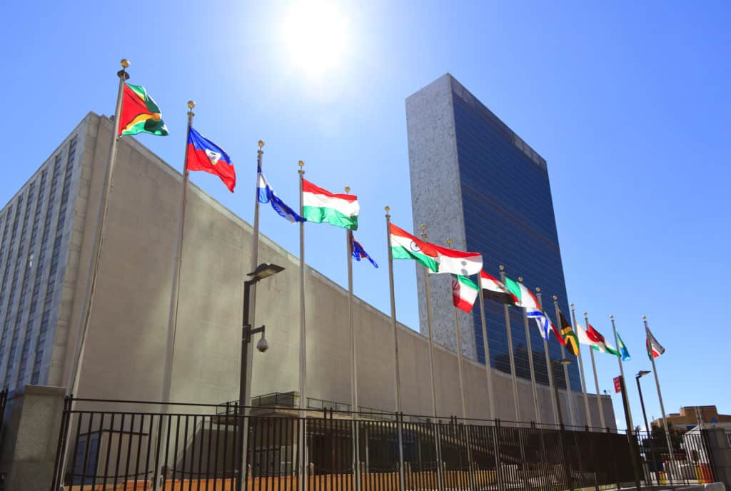 united nations headquarters buildings with multiple country flags on display outside