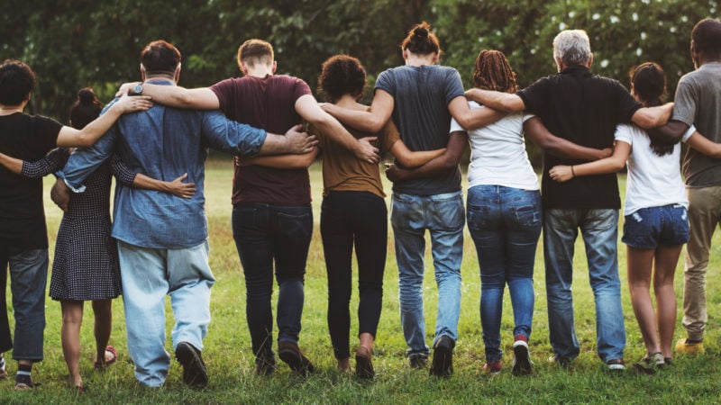 Line of people with arms around each other facing away from the camera