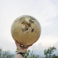 A hand holding a globe.