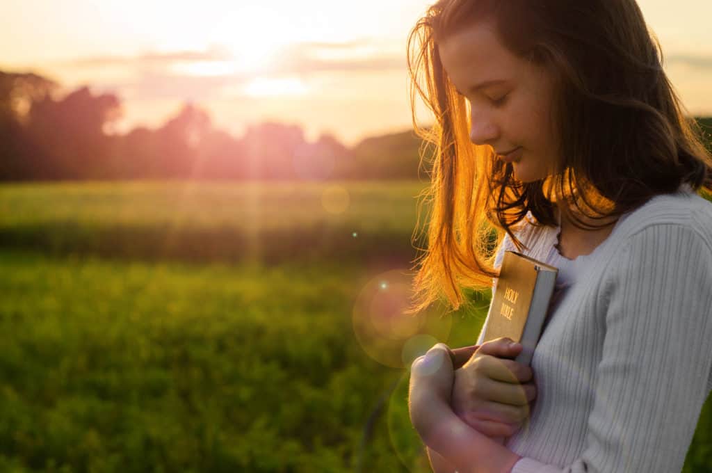 Young woman praying for Sabbath’s start, outside during Friday sunset.