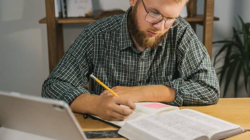 Man studying the Bible and taking notes.