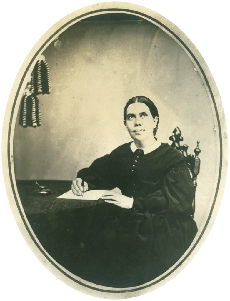 a portrait of Ellen G. White writing at her desk