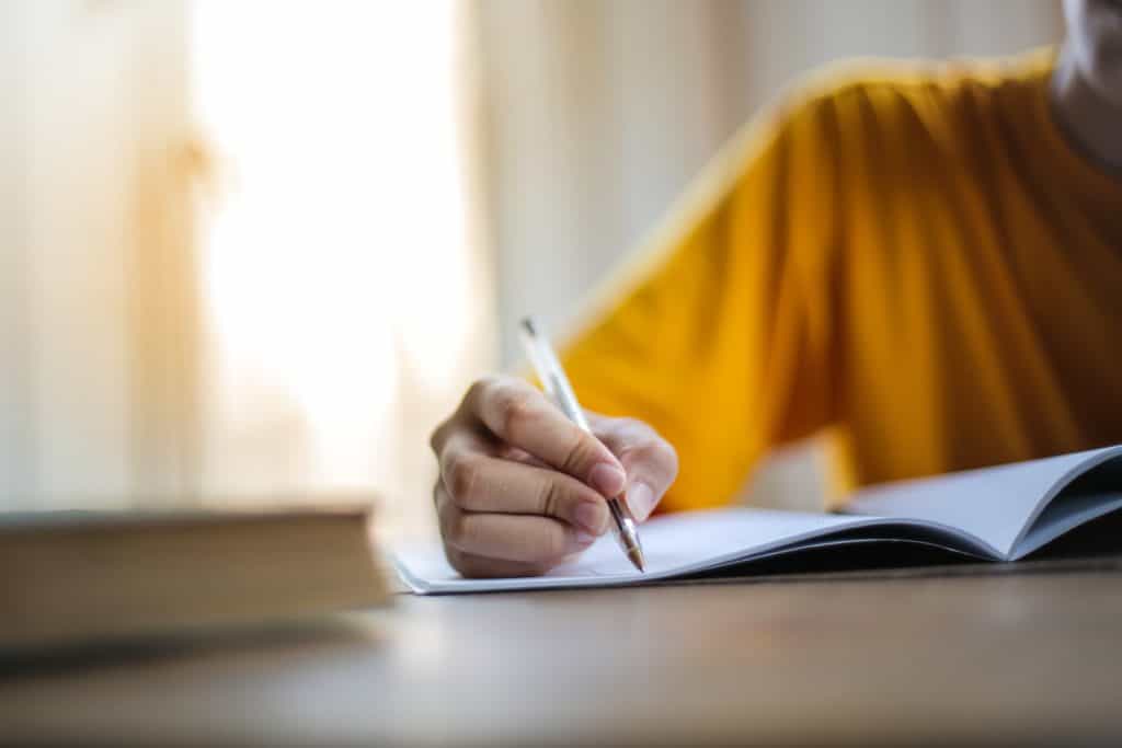 A person writing something down in a notebook.