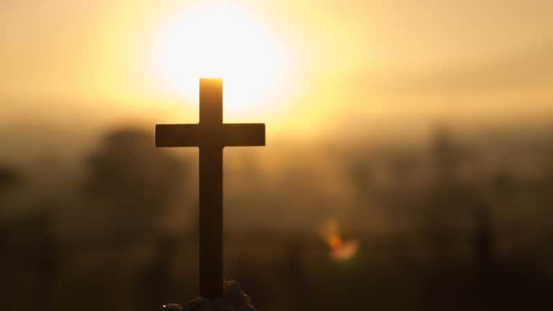 The cross in the sunrise colored sky background