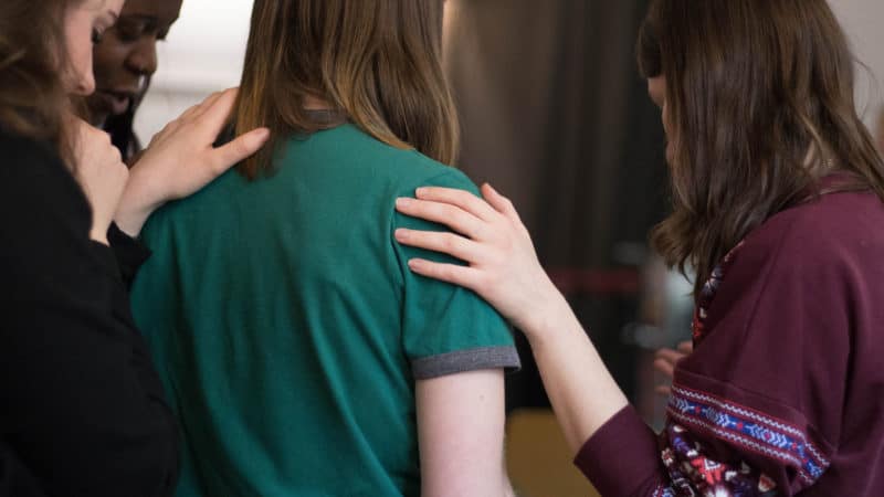 Friends supporting each other in prayer.