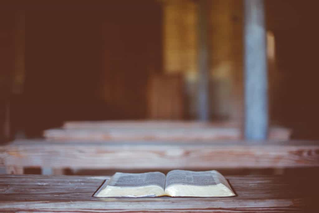 A Bible laying open on a wooden table. 