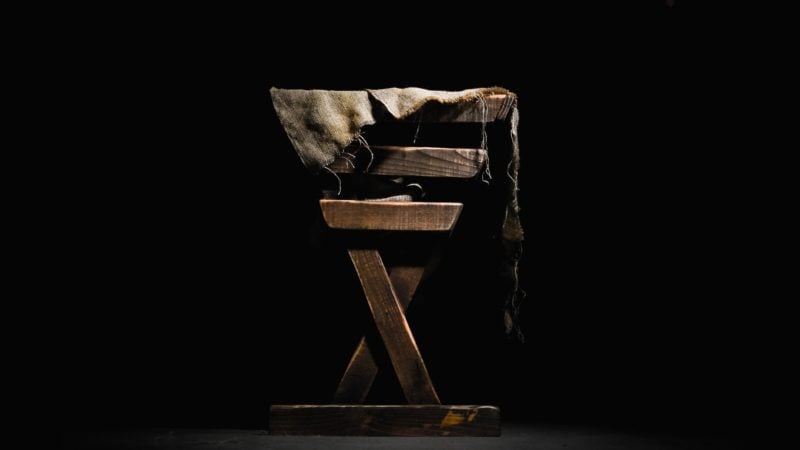 A manger against a black background as we study the birth of Jesus in a humble manner in a stable in Bethlehem