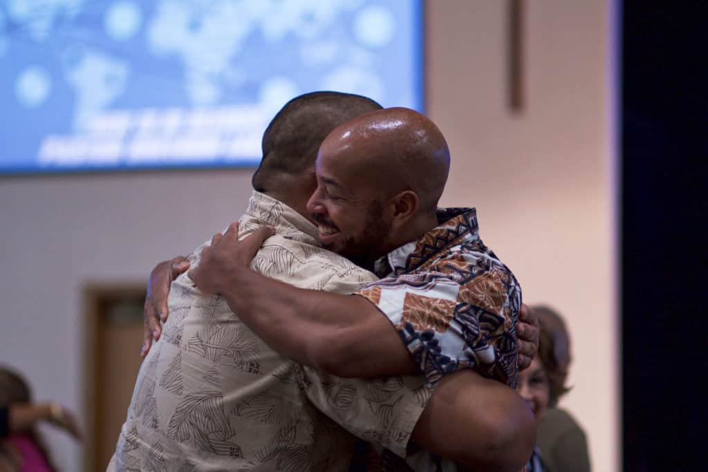 Two friends hugging at church. 