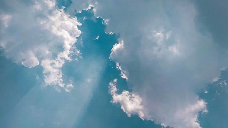 Light coming through the clouds in blue sky.