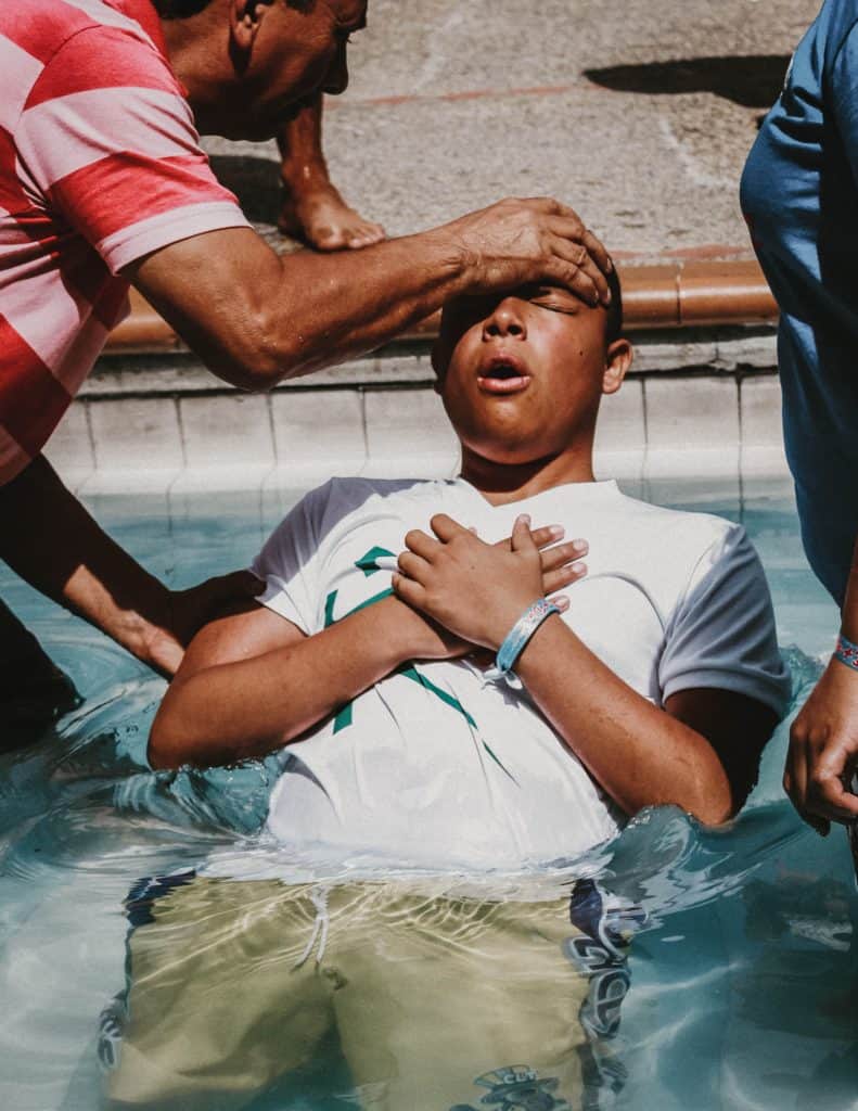 A young man being baptized.