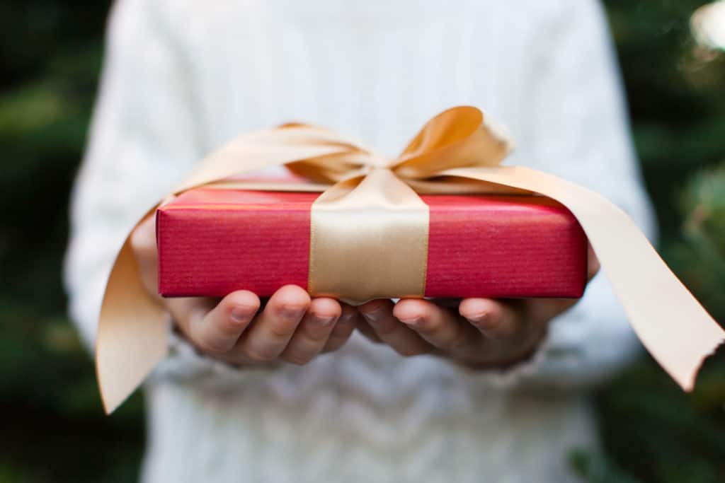 Close-up of nicely wrapped gift being held by a child with no face visible