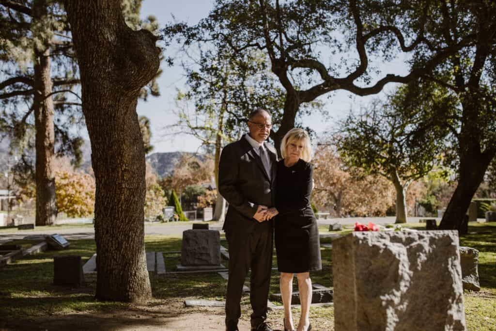 A couple holding hands at a grave.