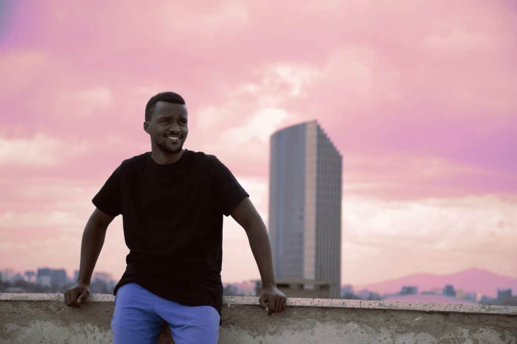 A happy man in front of a cityscape.