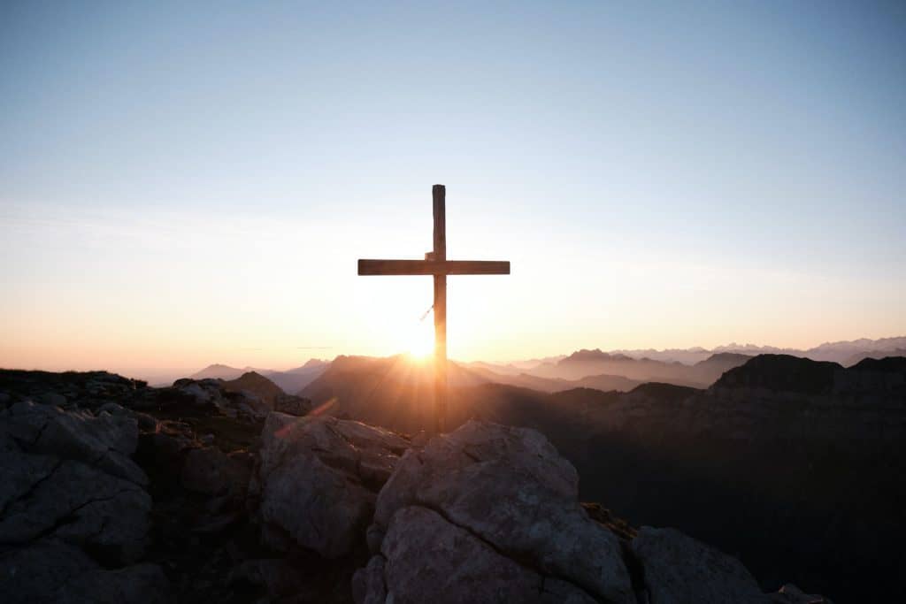 The cross with the setting sun behind it.