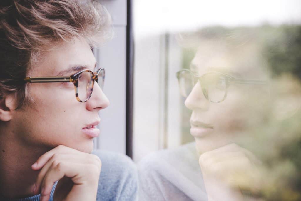 A young man looking out of a window.