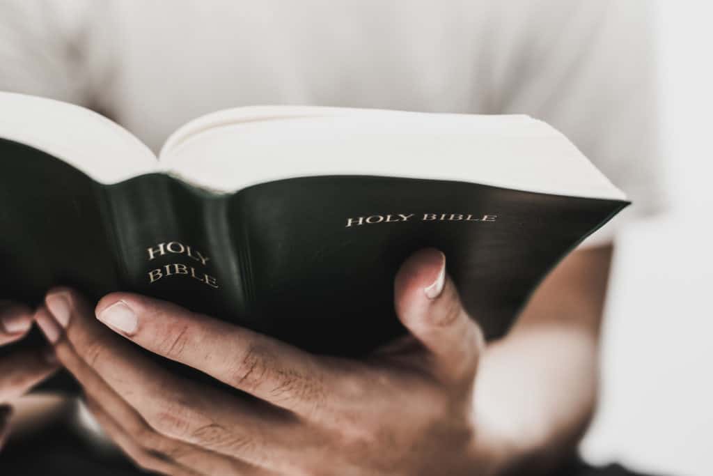 A closeup of hands holding a Bible.