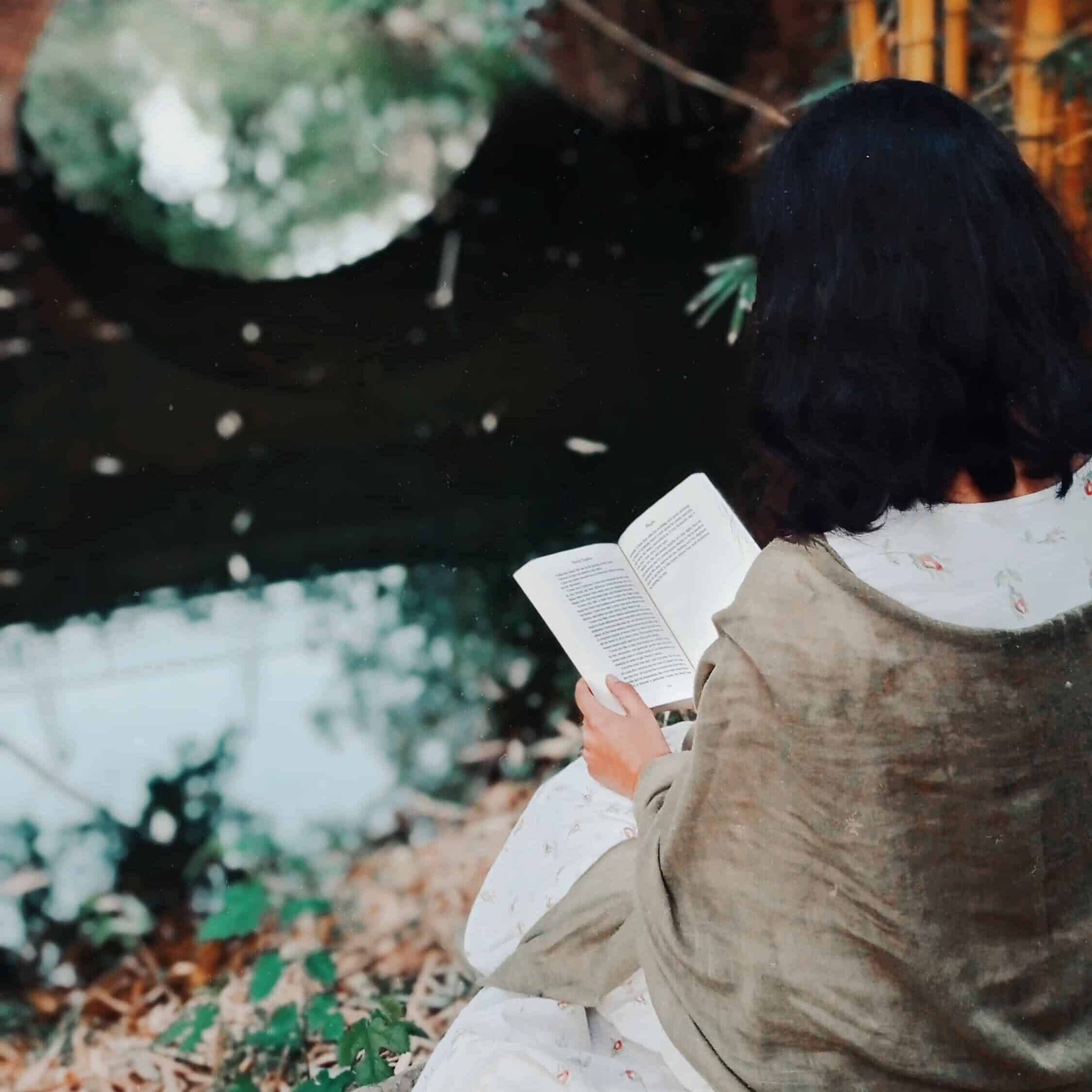 A woman reading in a garden.