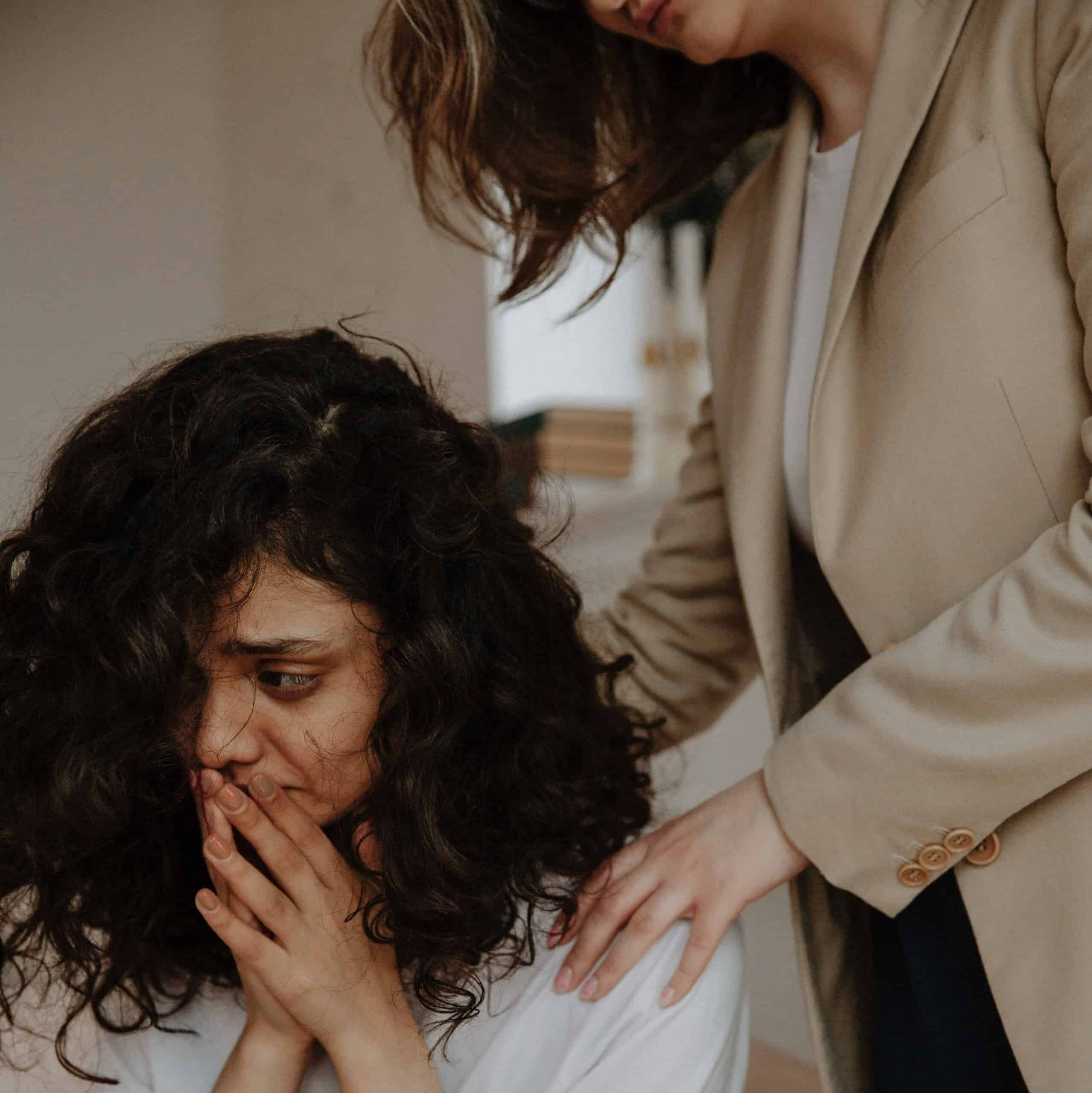 A friend comforting her grieving friend.