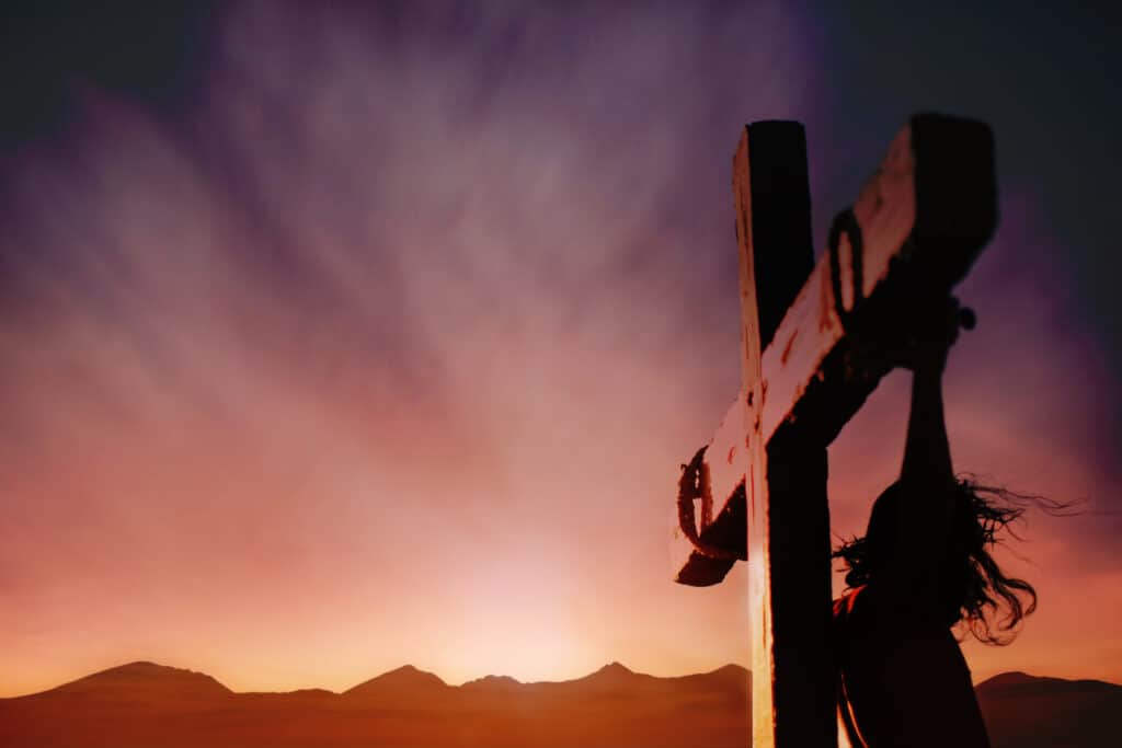 Jesus hanging on the cross with a dark sky above. 