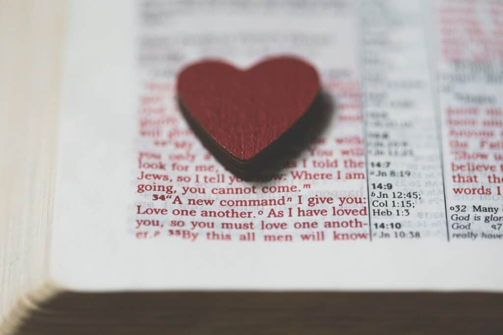 Wood heart on a open Bible page.