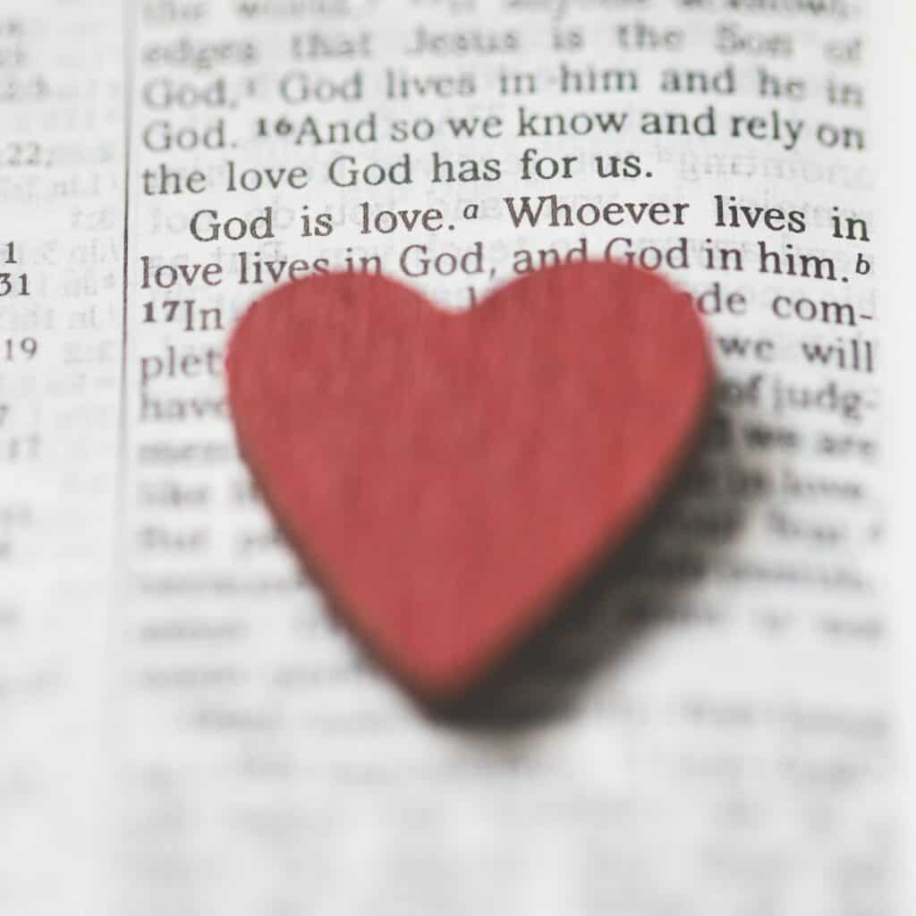Wooden heart laying on an open Bible. 