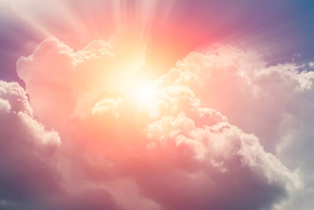 A bright sun shining through large clouds, representing Jesus's second coming in the clouds. 