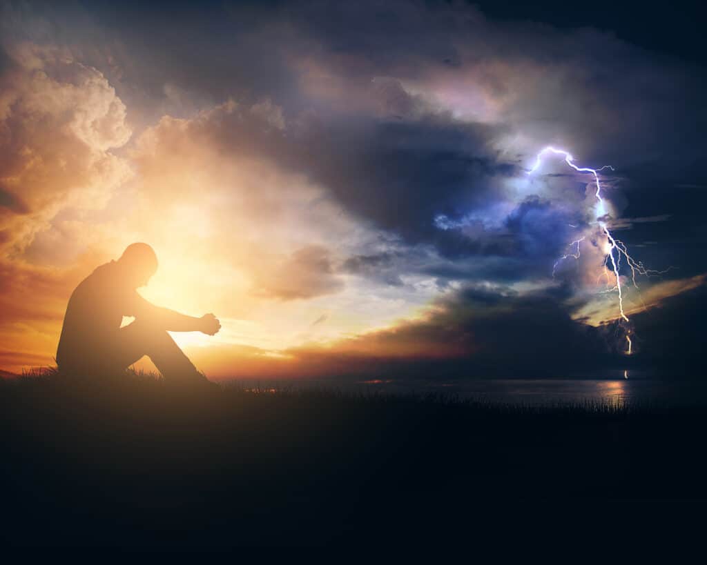 Man praying for protection outside, as off in the distance a cosmic battle happens seen only by extreme weather occurrences.