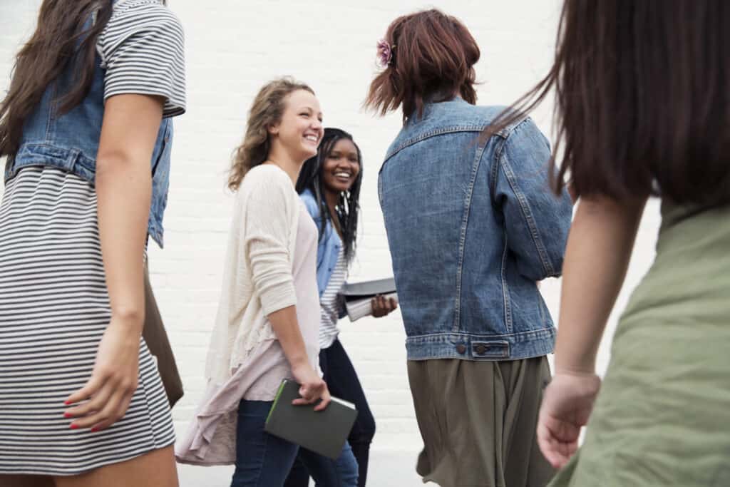 Group of friends walking and talking together happily despite having different beliefs.