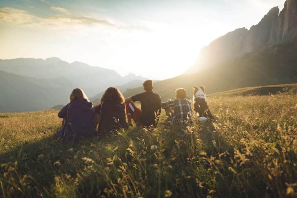 Family sitting together in a field watching the close of Sabbath sunset.