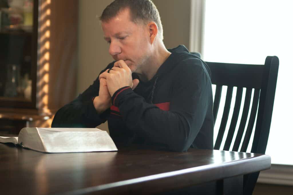 Man contemplating the Scripture he reads, as an answer to prayer.