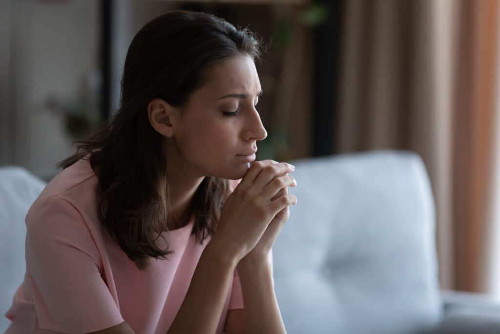 Woman praying alone, asking for help to make things right.