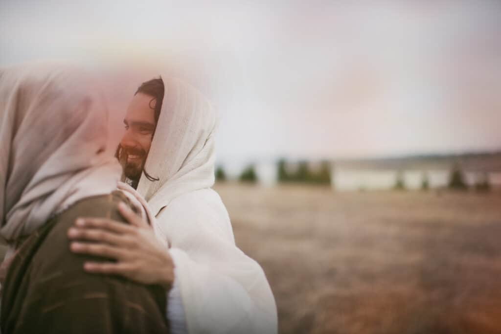 Jesus and a Disciple Jesus embracing one of his disciples as they walk together.