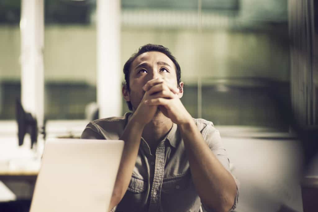 Man looking up in prayer for forgiveness of his sins after confessing.