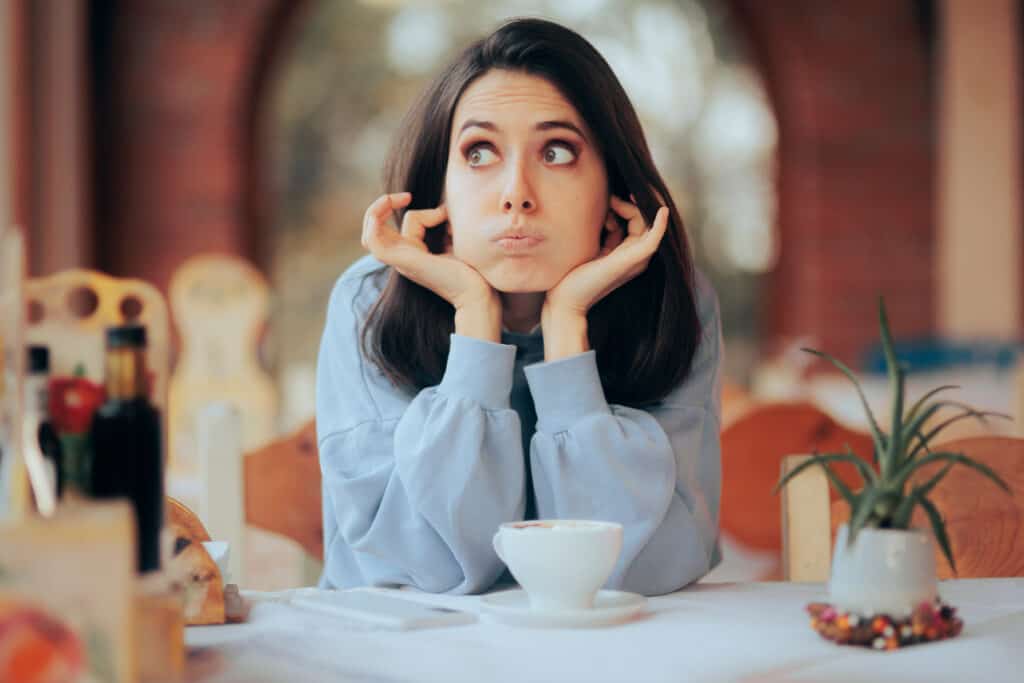 Woman with her fingers in her ears looking away to purposely block out what she doesn't like.