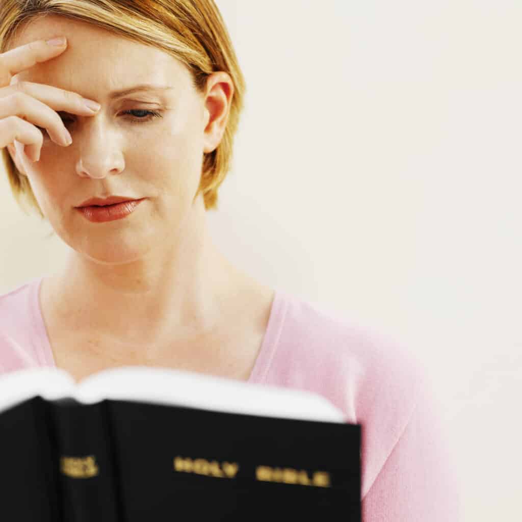 Woman holders her head while considering a confusing Scripture passage