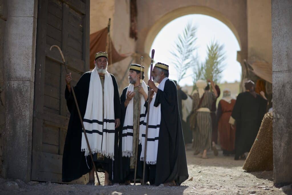 Three pharisees standing at the temple gate arguing about Jesus' words