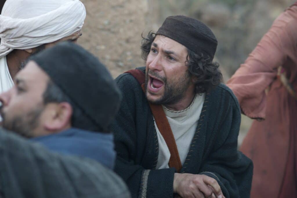 Two Israelites sitting on a rock in a debate with each other